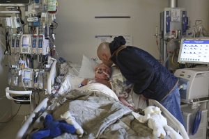 Brian kisses Rowan as Brian's stem cells flow into Rowan's body from bag hanging on the IV pole, left, in the pediatric intensive care unit at Seattle Children's Hospital on Oct. 18, 2016. Rowan's body rejected his first bone marrow transplant so his father, Brian, also a half-match, became the donor for a second one. Rowan's body, ravaged by the first treatment, had no immune system of his own. Days before the second transplant, Rowan fell into a coma because of an infection in his cerebral spinal fluid. Despite the second transplant, Rowan died Dec. 15, 2016, at the age of 10 from multiple organ failure and sepsis.
