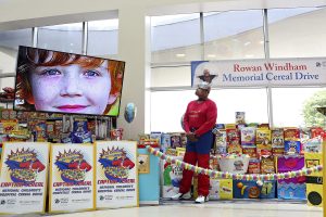 Capt. Cereal watches a video featuring photos of Rowan during the Rowan Windham Memorial Cereal Drive presentation at Methodist Children's Hospital on June 9, 2017.